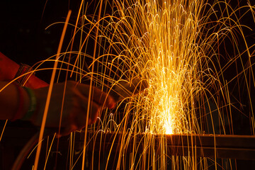 Iron welding close-up, sparks do not wear gloves. Welding sparks and fumes It can be dangerous to...
