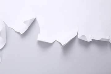 Torn paper sheet on gray background. Minimalistic background. Copy space