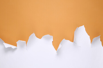White Torn paper sheet on beige background. Minimalistic background. Copy space