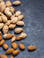 Roasted salted almonds on a dark table