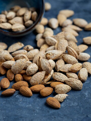 Roasted salted almonds on a dark table