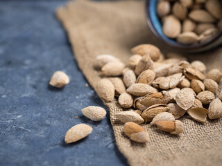 Roasted salted almonds on a dark table