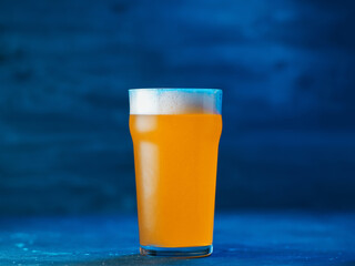 New England IPA craft beer glass on dark blue background