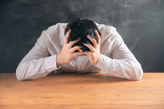 Tired Young Guy Holding His Head In His Hands