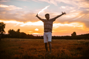 A man in the forest runs on the field, a happy man rejoices in freedom and tranquility. The guy in the field.