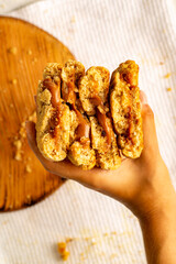 mano sosteniendo galletas con chispas de chocolate y rellenas de chocolate