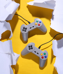 Retro gamepad on a yellow background with white torn paper. Trend shadow. Concept art. Minimalism © splitov27