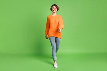 Fototapeta na wymiar Full size photo of attractive happy woman walk you wear casual outfit good mood isolated on green color background