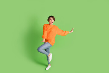 Fototapeta na wymiar Full length photo of excited charming young lady happy funky dance weekend isolated on green color background