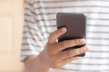 Hand holding and using smartphone.