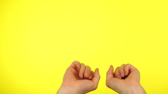 Hands dancing over yellow background. Wow, gesture of surprise by hands