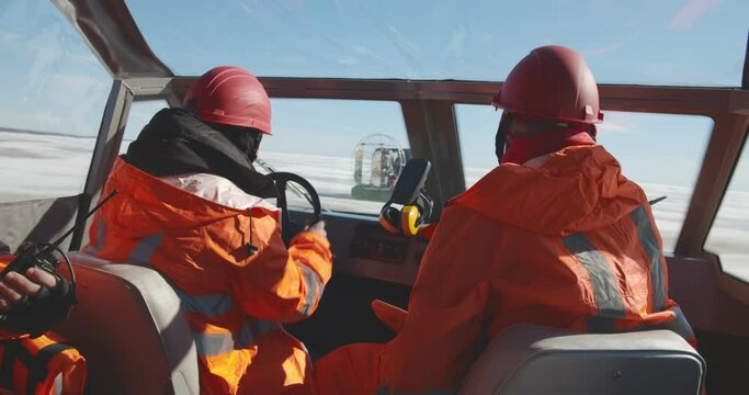 Rescue service team sailing airboat crossing frozen water area