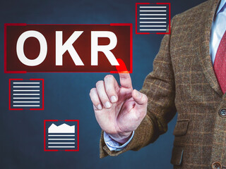 OKR Objectives and Key Results. The man clicks on the inscription.