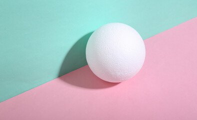 Ball on blue-pink background. Minimalism. Trendy shadow. Creative layout.