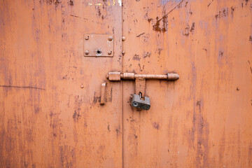 Old lock of the metal door.  Rusty old metal texture with remnants of the paint. Grungy background...