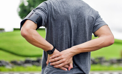 close up of young Asian sports man has pain at muscles and joints during outdoor exercise, over trainning or running and sport injuty concept