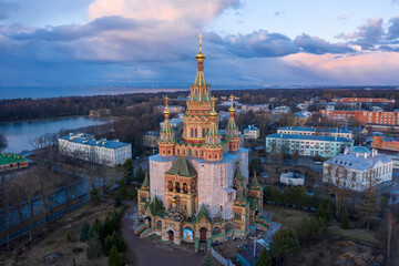A panoramic Aerial view of the Cathedral of Saints Peter and Paul, golden domes in the beautiful setting sun. Orthodox church in Peterhof. Facade of the church close-up.