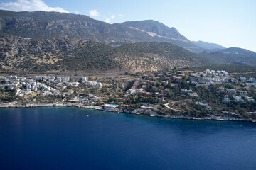 Aerial panoramic view of coastal town and mountains.