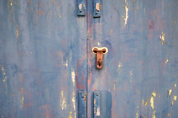 Old lock of the metal door.  Rusty old metal texture with remnants of the paint. Grungy background for any design. 
