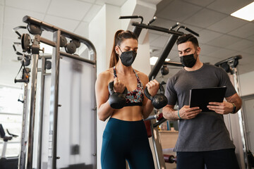 Personal trainer and fit woman training wearing face masks during pandemic