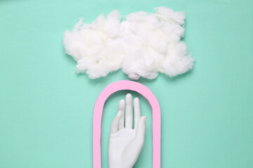 Creative minimalistic composition of a hand in arch and fluffy cloud. Layout. Flat lay abstraction