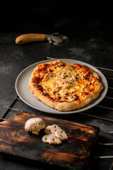 pizza con pollo y champiñones sobre fondo negro