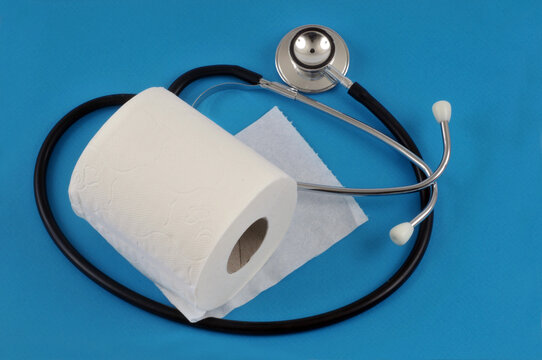 Concept de constipation avec un rouleau de papier toilette et un st&eacute;thoscope sur fond bleu