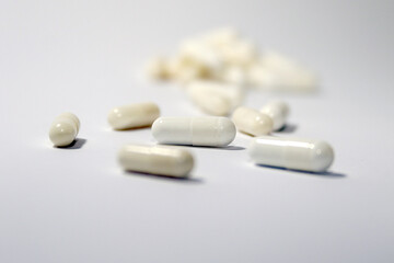 pills and capsules dropped on white background