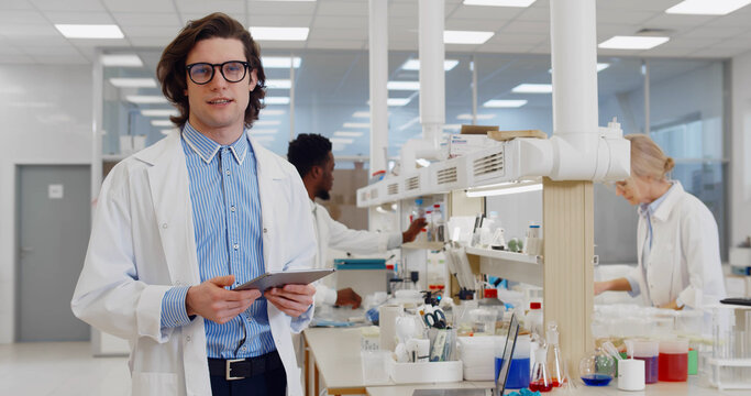 Chemist Using Tablet Computer In Lab Talking On Camera