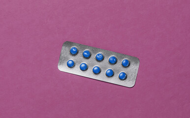 Minimalistic medical still life. Blister of pills on purple background