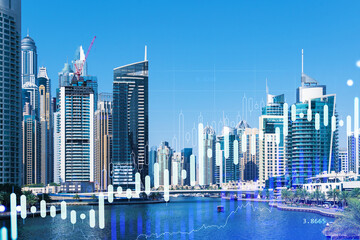 Fototapeta premium Skyscrapers of Dubai business downtown. International hub of trading and financial services of Western Asia. FOREX graph and chart concept. Double exposure. Dubai Canal waterfront.