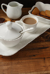 Coffee cup and cookies on a tray on wooden table