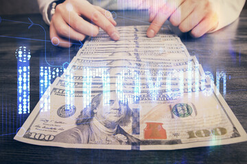 Double exposure of technology drawing hologram and us dollars bills and man hands. Data concept