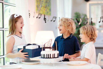 Music and piano birthday party. Kid with cake.
