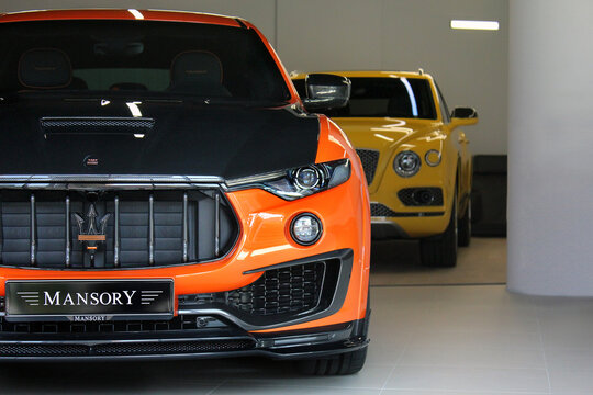 Kiev, Ukraine - September 9, 2017: Mansory Maserati Levante  on the background of Bentley Bentayga Mansory. Two luxury SUVs in bright colors in the garage