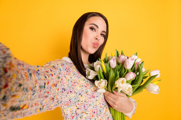 Photo portrait of woman with pouted lips taking selfie with tulips bouquet isolated on bright yellow color background