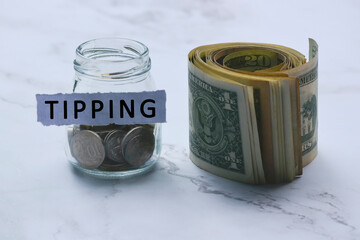 Text on white torn paper with coins in a glass jar and US dollar bills