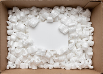 A cardboard box with packing styro foam pellets top view