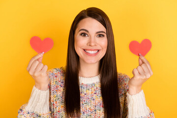 Photo portrait of brunette woman showing red hearts smiling isolated on bright yellow color background