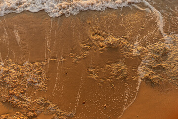 Waves by the rocky seashore with sandy beach at the Egypt resort. Top view background with copy space