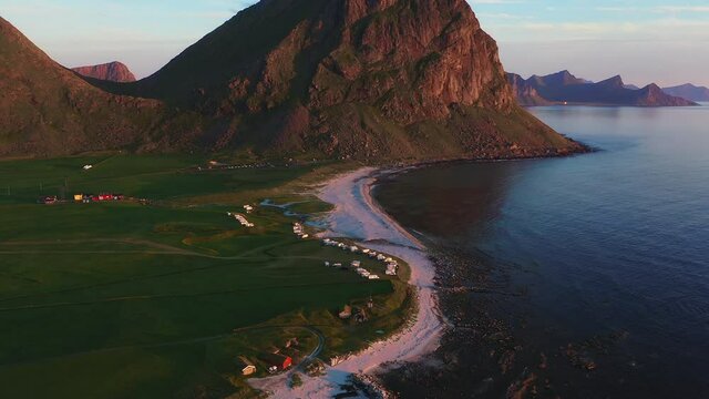 Aerial Side View of Uttakleiv Beach on a Summer Evening with Mountain Backdrop
