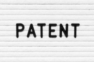 Black alphabet letter in word patent on white felt board background