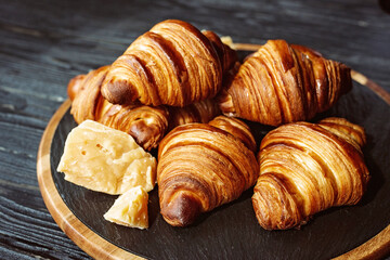 Fresh baked croissants. Warm fragrant butter croissants and rolls on a stone stand. French and American pastries.