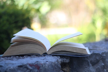Open book in a garden. Selective focus.