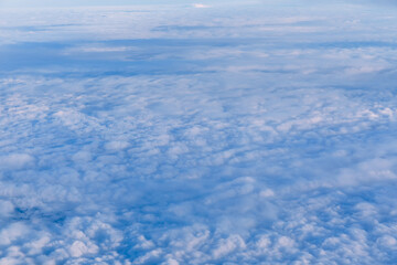 Above clouds, view from pilot cabin in airplane. Aerial view abo