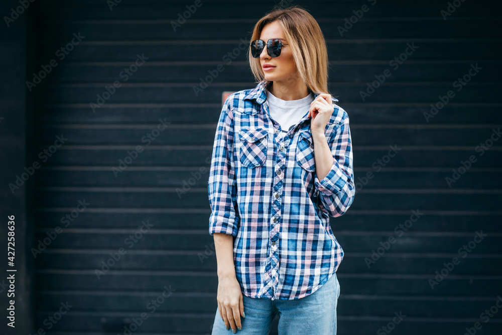 Wall mural fashion portrait of beautiful woman with beautiful face, wearing grunge plaid shirt. posing alone on