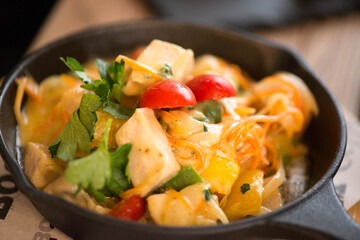delicious fried chicken fillet in a pan with herbs and tomatoes