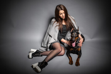 Fototapeta na wymiar Portrait of a Doberman dog with a girl owner. Isolated Studio photo on a black background