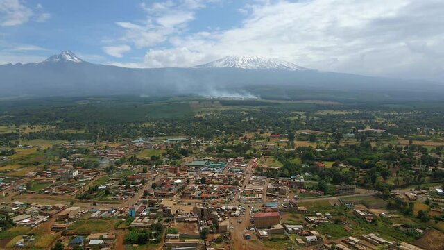 Grasslands burning  accident near a town in the Eastern Africa - Aerial reverse drone shot