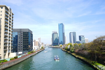 Fototapeta na wymiar Osaka skyline along with Neya river (Neyagawa) in Japan . Panoramic view. - 寝屋川と大阪のビル群 水上バス 日本
